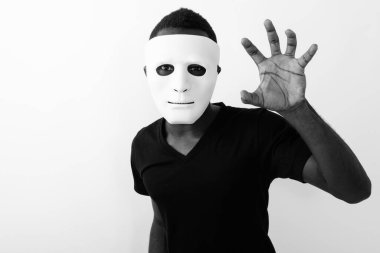 Siyah beyaz arka planda maskesi olan Afrikalı genç bir adamın stüdyo fotoğrafı.