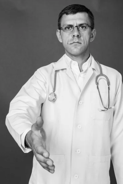 Studio Záběr Pohledný Muž Lékař Proti Šedé Pozadí Černé Bílé — Stock fotografie