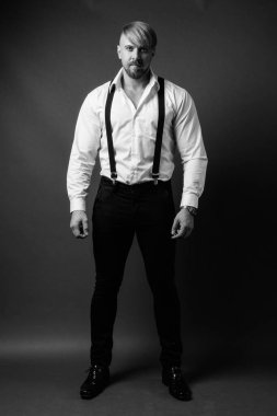 Stüdyo resmi, sarı saçlı sakallı adam siyah beyaz arka planda.