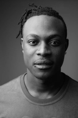 Kenyalı yakışıklı Afrikalı genç adamın, siyah beyaz gri arka plandaki çekimlerine karşı.