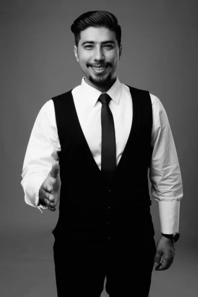 黒と白の灰色の背景を持つ若いひげを生やしたイランのビジネスマンのスタジオショット — ストック写真