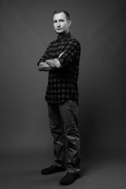 Hipster 'ın gri arkaplana karşı siyah beyaz çekimleri.