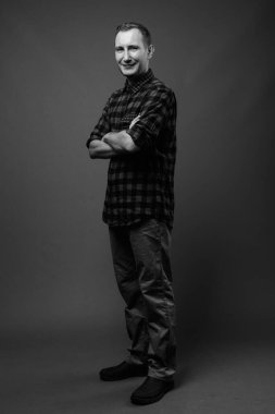 Hipster 'ın gri arkaplana karşı siyah beyaz çekimleri.