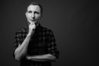 Hipster 'ın gri arkaplana karşı siyah beyaz çekimleri.