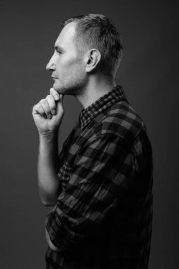 Hipster 'ın gri arkaplana karşı siyah beyaz çekimleri.