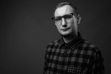 Hipster 'ın gri arkaplana karşı siyah beyaz çekimleri.