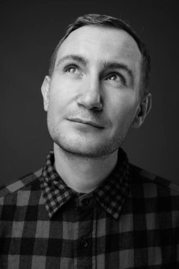 Hipster 'ın gri arkaplana karşı siyah beyaz çekimleri.