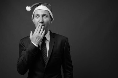 İş adamının gri arka planda siyah beyaz takım elbise giydiği bir fotoğraf.