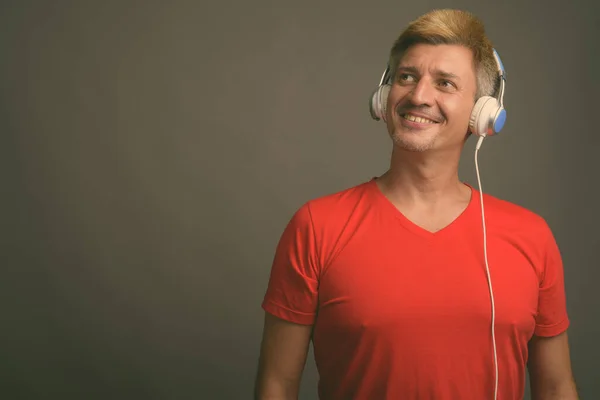 Studio Shot Van Man Met Blond Haar Luisteren Naar Muziek — Stockfoto