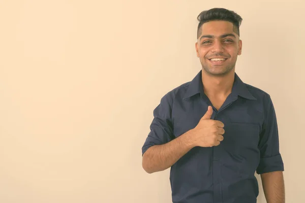 若い幸せなインドのビジネスマンのスタジオショットは白い背景に親指を放棄 — ストック写真