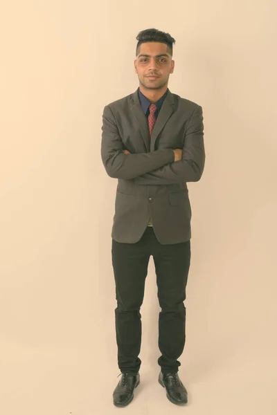 白い背景に腕を組んで若いインド人実業家のスタジオショット — ストック写真
