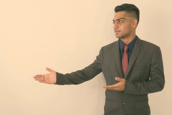 Studioaufnahme Eines Jungen Indischen Geschäftsmannes Anzug Während Etwas Vor Weißem — Stockfoto