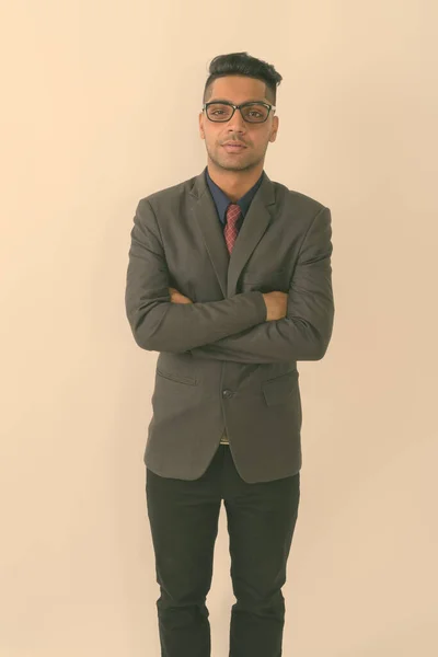 白い背景に腕を組んで眼鏡をかけた若いインド人ビジネスマンのスタジオショット — ストック写真