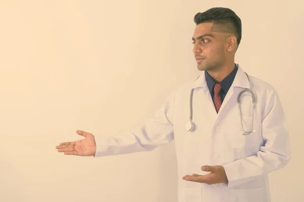 Profil Widok Młody Indyjski Człowiek Lekarz Pokazując Coś Białym Tle — Zdjęcie stockowe