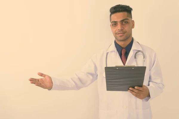 Studioaufnahme Eines Jungen Indischen Arztes Mit Klemmbrett Vor Weißem Hintergrund — Stockfoto