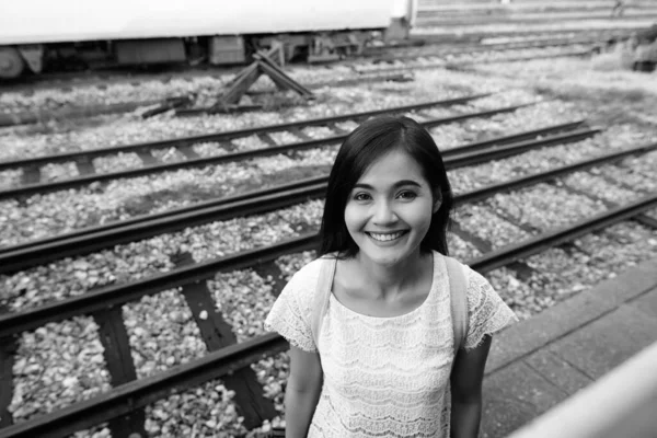 白纸黑字的年轻美丽的亚洲女游客在火车站的画像 — 图库照片