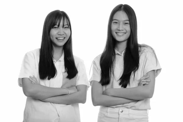 スタジオショットの二人の若いです美しいですアジアのティーン女の子一緒に隔離された背景に白で黒と白 — ストック写真