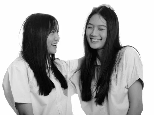 スタジオショットの二人の若いです美しいですアジアのティーン女の子一緒に隔離された背景に白で黒と白 — ストック写真