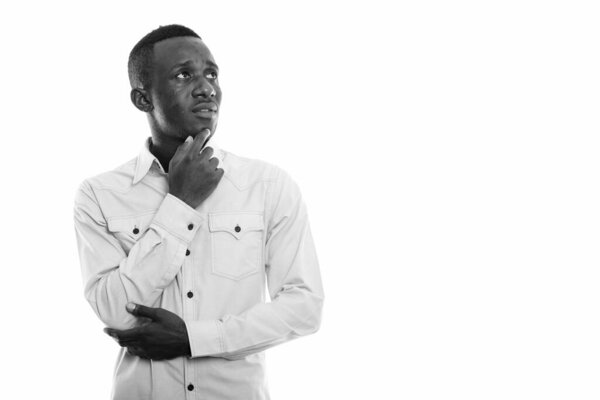 Studio shot of young African businessman isolated against white background in black and white