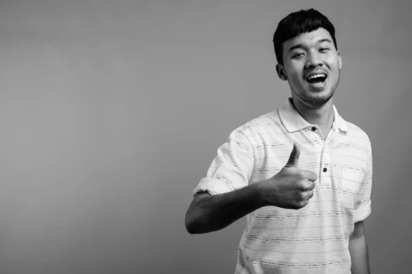 Estudio Joven Asiático Con Camisa Polo Rayas Sobre Fondo Gris —  Fotos de Stock