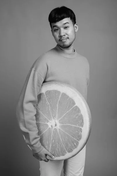 Studio Shot Young Asian Man Wearing Sweater While Holding Orange — Stock Photo, Image