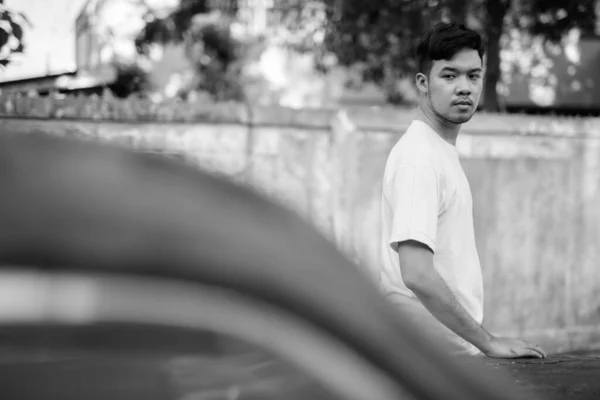 亚洲年轻人的画像 他们穿着黑白相间的衣服站在街上 满街都是生锈的老爷车 — 图库照片