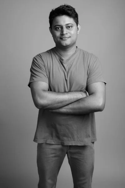 スタジオショットの若いですインド人男性身に着けているシャツに対してグレー背景で黒と白 — ストック写真