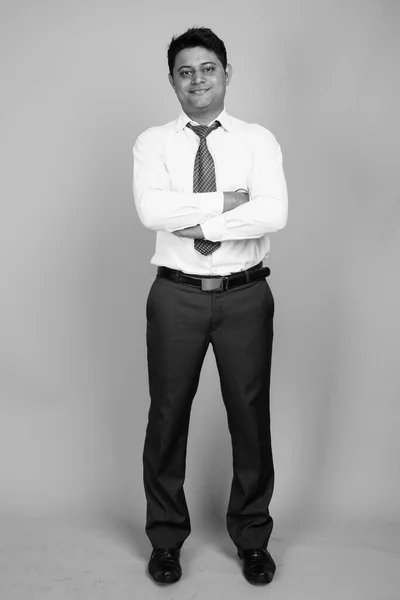 演播室拍摄的年轻印度商人身穿白衬衫 打着灰色背景的黑白相间的领带 — 图库照片