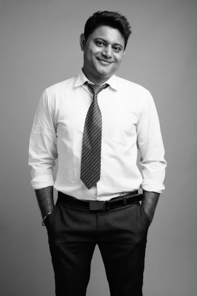 スタジオショットの若いインドのビジネスマンの白いシャツを着て黒と白のグレーの背景にネクタイ — ストック写真