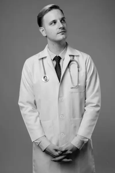 스튜디오에서는 흑백으로 배경에 금발의 잘생긴 의사를 촬영하였다 — 스톡 사진