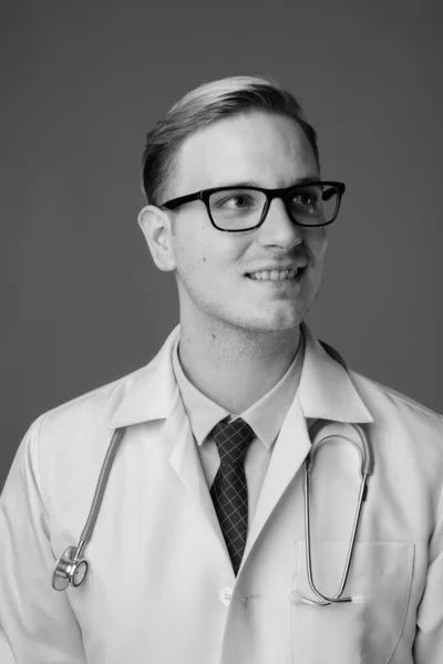 Estudio Joven Guapo Doctor Con Pelo Rubio Sobre Fondo Gris —  Fotos de Stock