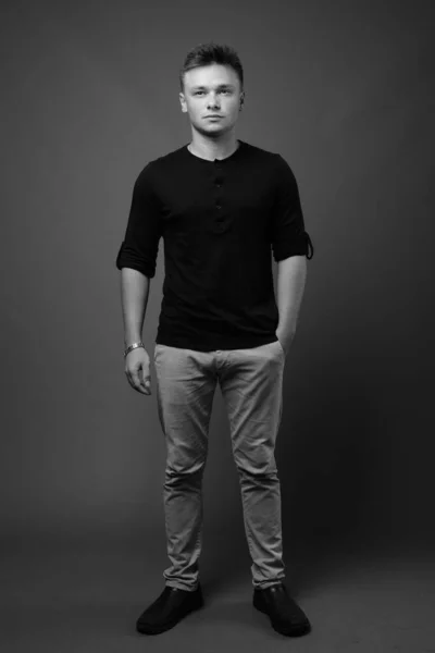 Estudio Joven Hombre Guapo Con Camisa Negra Sobre Fondo Gris — Foto de Stock