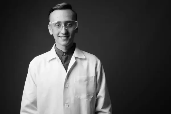 Estudio Joven Guapo Doctor Con Gafas Protectoras Sobre Fondo Gris — Foto de Stock