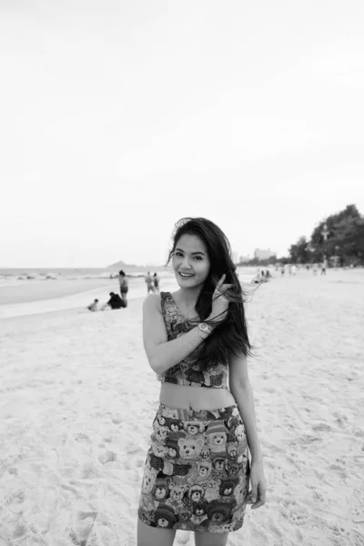 年轻美丽的亚洲女人穿着黑白相间的衣服在海滩上放松的画像 — 图库照片