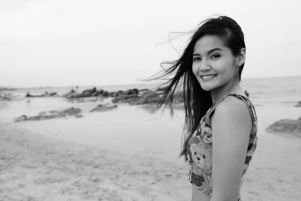 年轻美丽的亚洲女人穿着黑白相间的衣服在海滩上放松的画像 — 图库照片