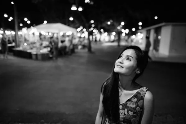 年轻美丽的亚洲女子在黑白夜市放松的画像 — 图库照片