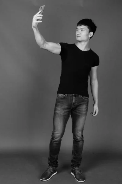 Studio Záběr Mladého Čínského Muže Černé Košili Proti Šedé Pozadí — Stock fotografie