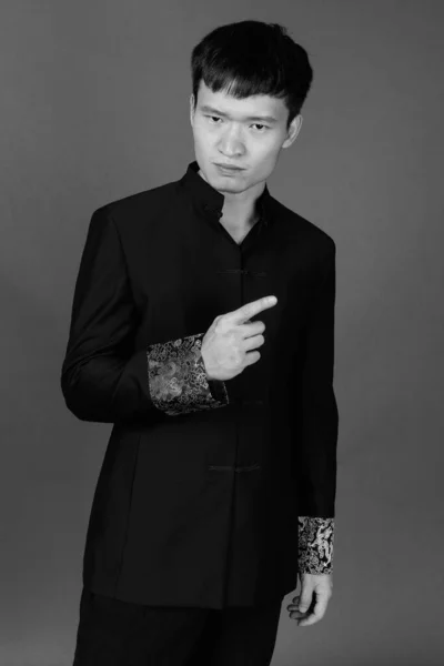 Studio Skott Ung Kinesisk Man Bär Traditionella Kläder Mot Grå — Stockfoto