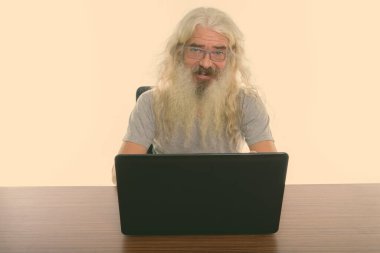 Uzun beyaz kıvırcık sakallı ve beyaz arka planda izole olmuş yakışıklı yaşlı adamın stüdyo fotoğrafı.