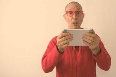 Beyaz arka planda ceketli kel bir adamın stüdyo fotoğrafı.