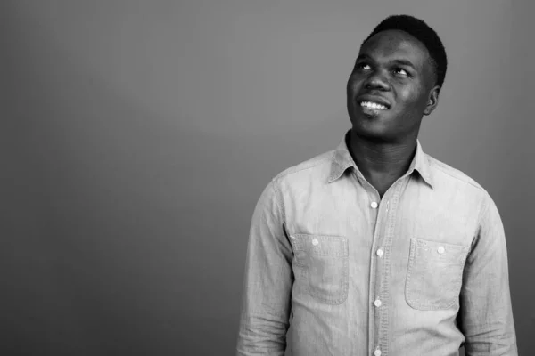 Estudio Joven Africano Con Camisa Vaquera Sobre Fondo Gris Blanco —  Fotos de Stock