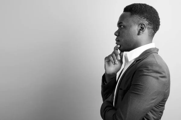 黒と白の白い背景にスーツを着て若いアフリカのビジネスマンのスタジオショット — ストック写真