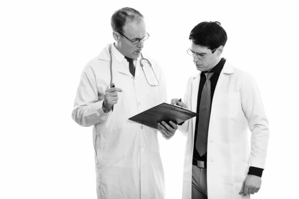 成人男医生与年轻男医生在黑白背景下隔离的演播室拍摄 — 图库照片
