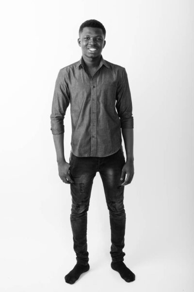 Studio shot of young African businessman against white background in black and white