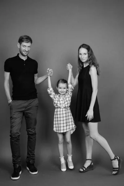 灰色の背景に対して一緒に若いロシアの家族の絆のスタジオショット — ストック写真