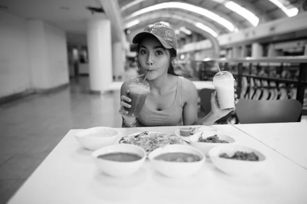 在黑白餐厅享用印度美食的年轻美丽亚洲女游客的画像 — 图库照片