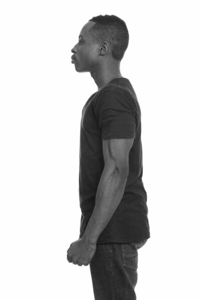 Studio shot of young handsome African man isolated against white background in black and white