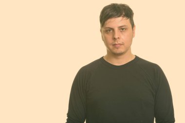 Beyaz arka planda uzun kollu gömlek giyen bir adamın stüdyo fotoğrafı.