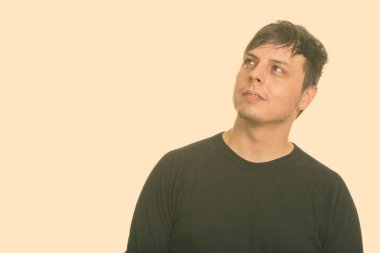 Beyaz arka planda uzun kollu gömlek giyen bir adamın stüdyo fotoğrafı.