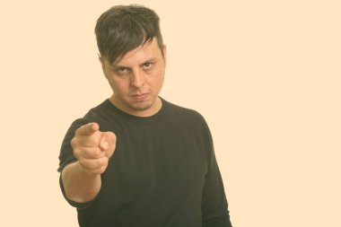 Beyaz arka planda uzun kollu gömlek giyen bir adamın stüdyo fotoğrafı.